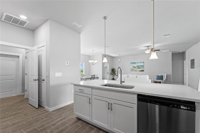 kitchen featuring stainless steel dishwasher, ceiling fan with notable chandelier, sink, white cabinetry, and hanging light fixtures