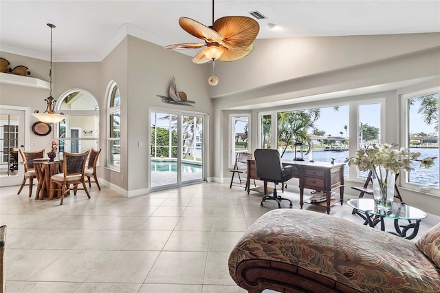 tiled living room featuring a towering ceiling, ceiling fan, and a wealth of natural light