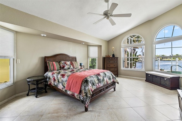 bedroom with light tile floors, ceiling fan, and a water view