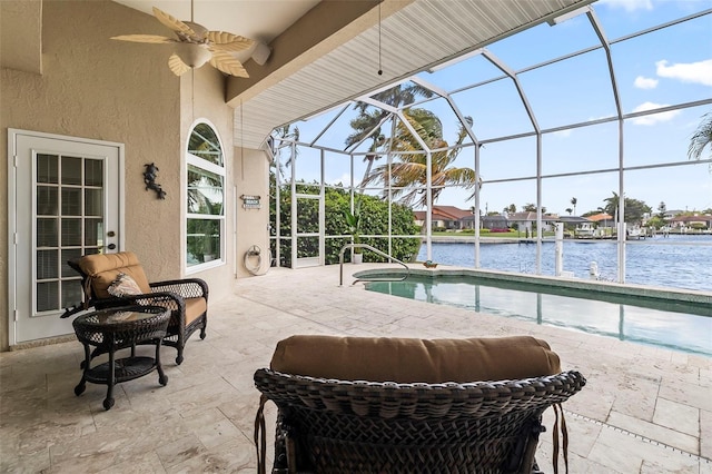 view of swimming pool with glass enclosure, a water view, ceiling fan, and a patio area