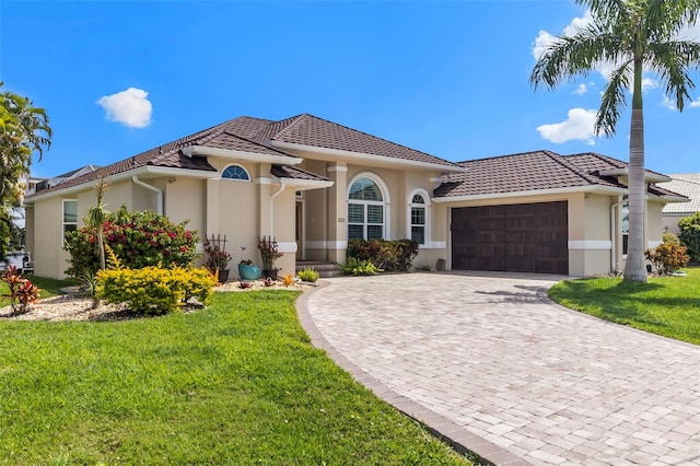 mediterranean / spanish home with a front lawn and a garage