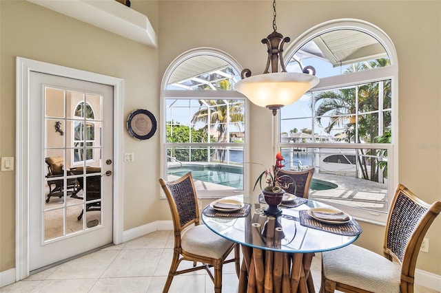 dining space with a chandelier and light tile floors