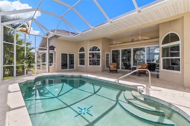 view of swimming pool with ceiling fan, glass enclosure, and a patio