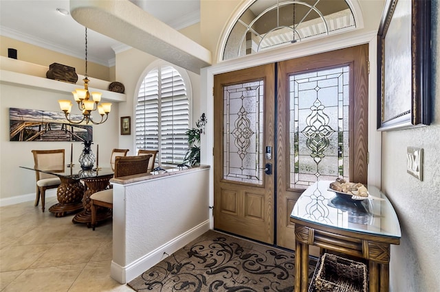 tiled foyer with ornamental molding and an inviting chandelier