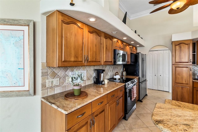 kitchen with ceiling fan, backsplash, stainless steel appliances, light tile flooring, and light stone countertops