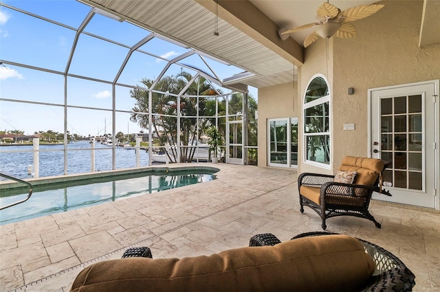 view of swimming pool featuring a lanai, a water view, a patio area, and ceiling fan