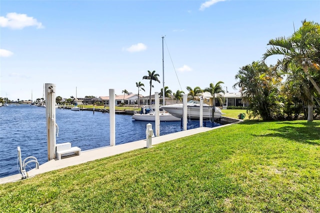 view of dock with a lawn and a water view