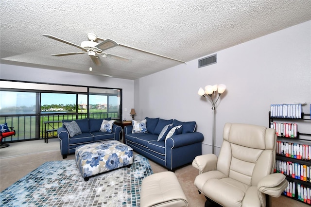 carpeted living room with a textured ceiling and ceiling fan