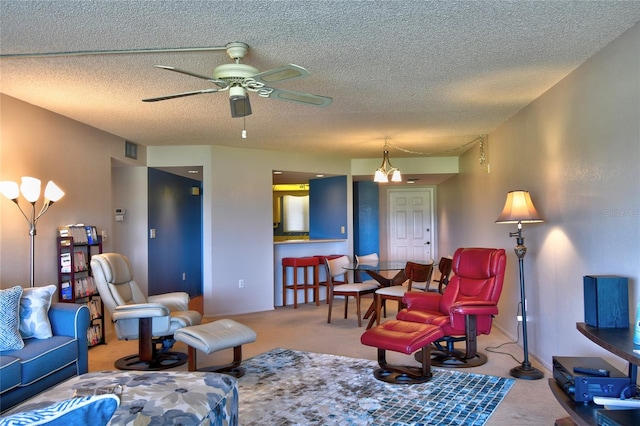 living room with light carpet, ceiling fan, and a textured ceiling