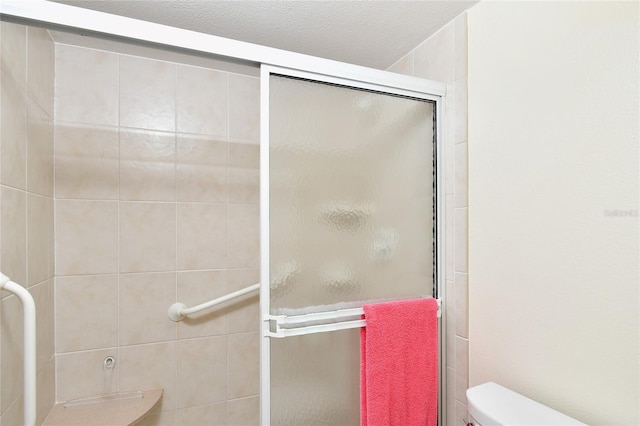 bathroom with an enclosed shower and toilet