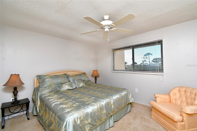 carpeted bedroom featuring ceiling fan and a textured ceiling