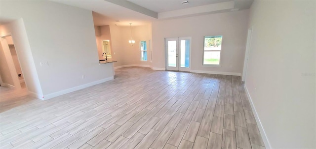 unfurnished living room featuring light hardwood / wood-style flooring and french doors