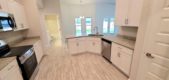 kitchen with decorative light fixtures, sink, light stone counters, appliances with stainless steel finishes, and white cabinets