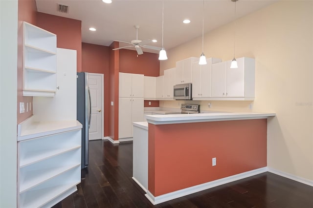 kitchen featuring kitchen peninsula, decorative light fixtures, dark wood-type flooring, white cabinetry, and appliances with stainless steel finishes