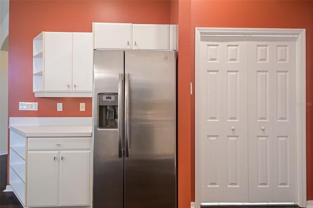 kitchen with stainless steel fridge and white cabinetry