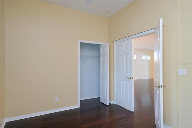 unfurnished bedroom with dark wood-type flooring and a closet