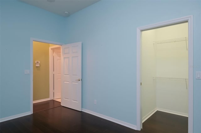 unfurnished bedroom featuring a closet and dark hardwood / wood-style floors