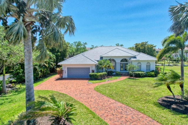 view of front of house featuring a front lawn and a garage