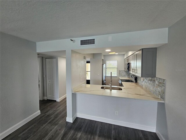 kitchen with gray cabinetry, stove, hardwood / wood-style flooring, and sink