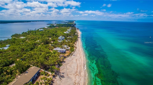 birds eye view of property with a water view and a beach view