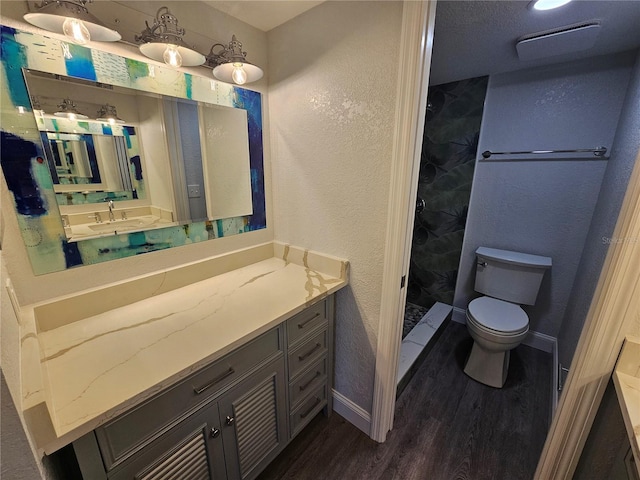 bathroom featuring walk in shower, toilet, vanity, and hardwood / wood-style floors