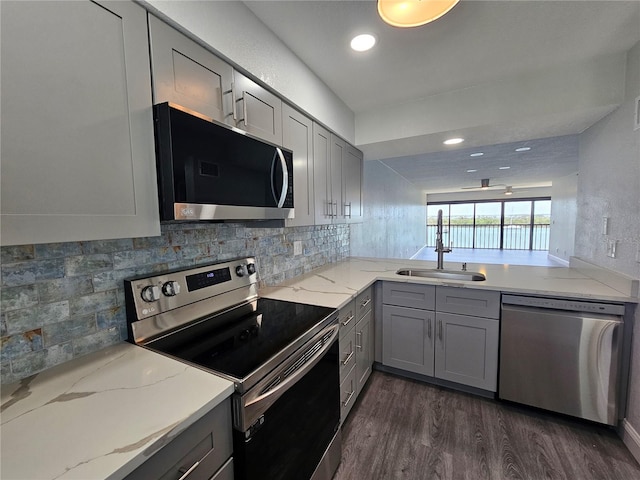 kitchen featuring appliances with stainless steel finishes, sink, dark hardwood / wood-style flooring, and gray cabinets