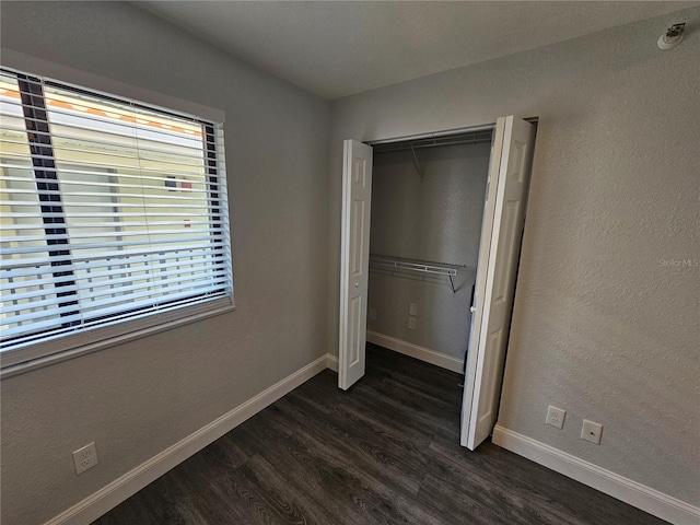 unfurnished bedroom featuring hardwood / wood-style floors and a closet