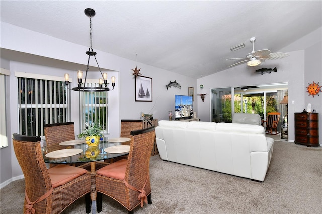 carpeted dining space with ceiling fan with notable chandelier and vaulted ceiling