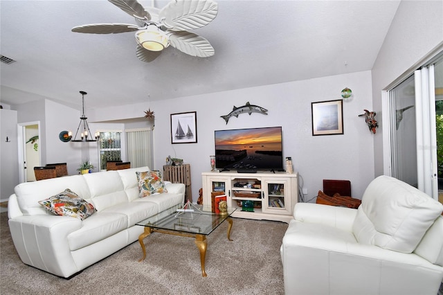 living room featuring ceiling fan with notable chandelier and carpet