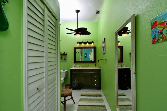 bathroom featuring toilet, ceiling fan, tile floors, a textured ceiling, and vanity