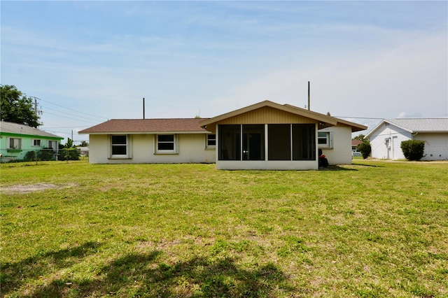 rear view of house with a yard and a sunroom