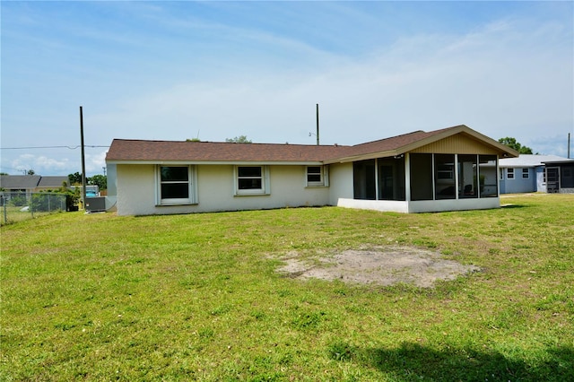 back of property featuring a lawn and a sunroom