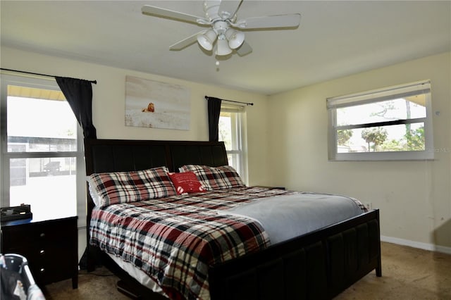 bedroom featuring light colored carpet, multiple windows, and ceiling fan