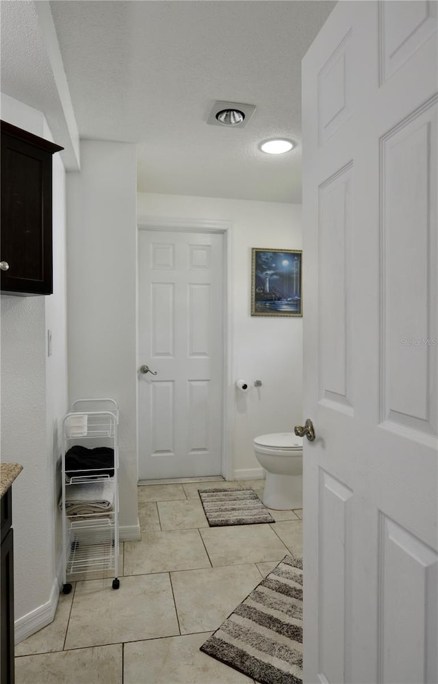 bathroom featuring vanity, toilet, and tile floors