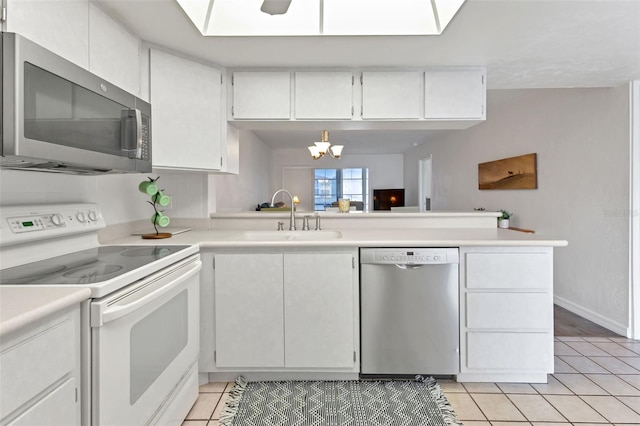 kitchen with sink, stainless steel appliances, white cabinets, kitchen peninsula, and light tile patterned flooring