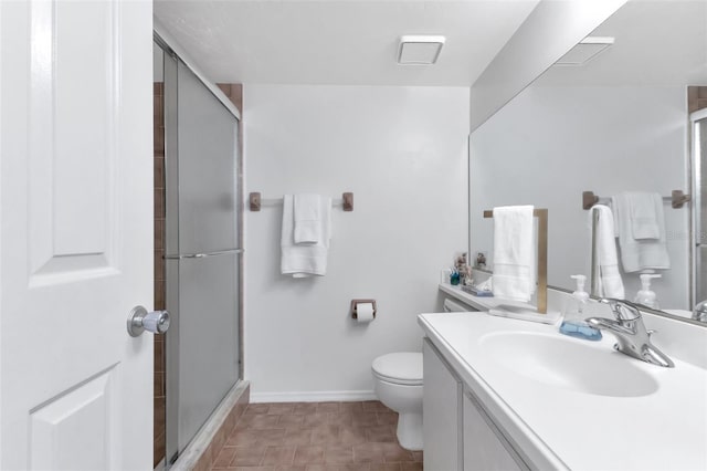 bathroom featuring vanity, toilet, and a shower with door