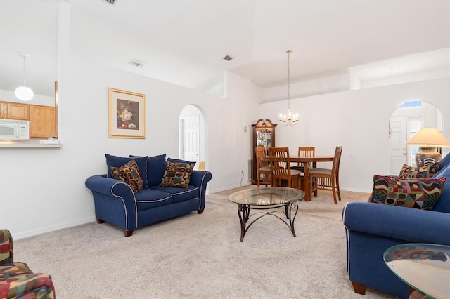 carpeted living room with lofted ceiling and a notable chandelier