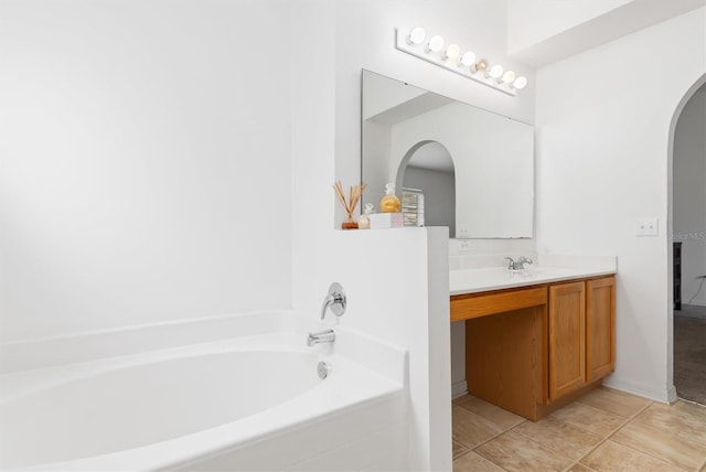 bathroom with a bath, large vanity, and tile flooring