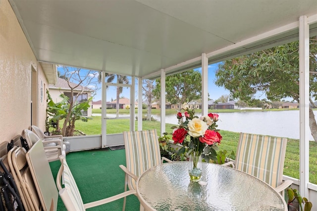 sunroom featuring plenty of natural light and a water view