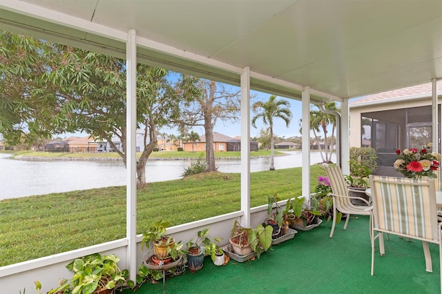 sunroom featuring a water view