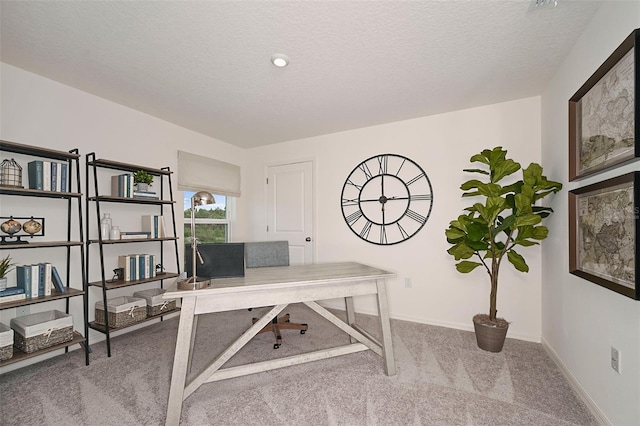 carpeted home office featuring a textured ceiling