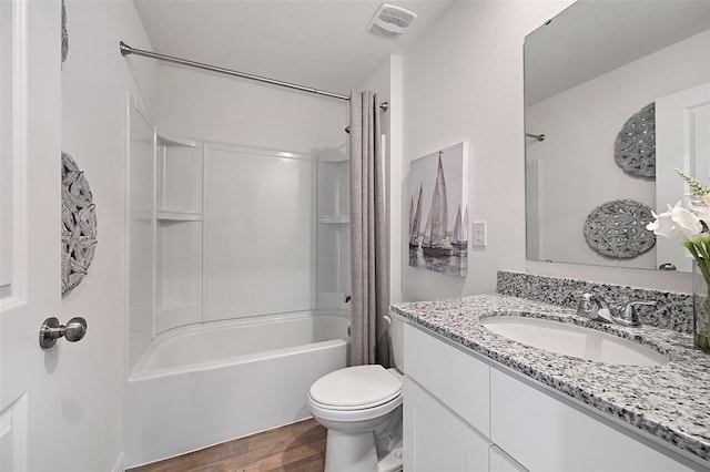 full bathroom featuring hardwood / wood-style flooring, washtub / shower combination, vanity, and toilet