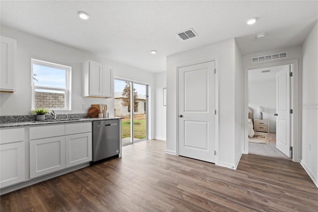 kitchen featuring dark wood-type flooring, sink, white cabinetry, dishwasher, and light stone countertops