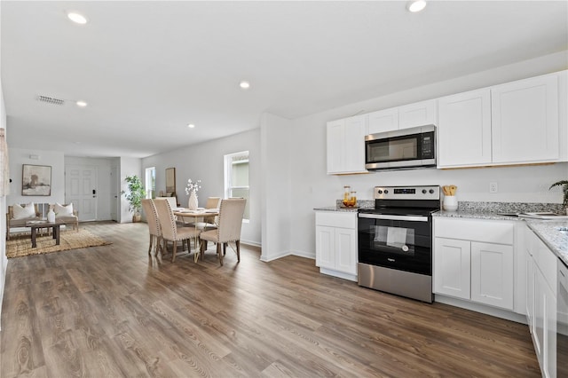 kitchen with white cabinetry, stainless steel appliances, and hardwood / wood-style flooring