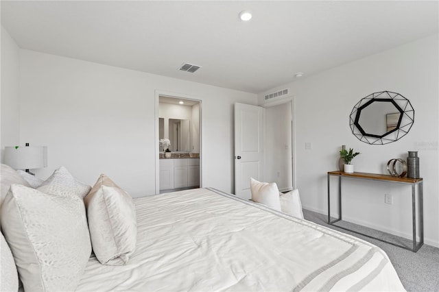 bedroom featuring light carpet and connected bathroom