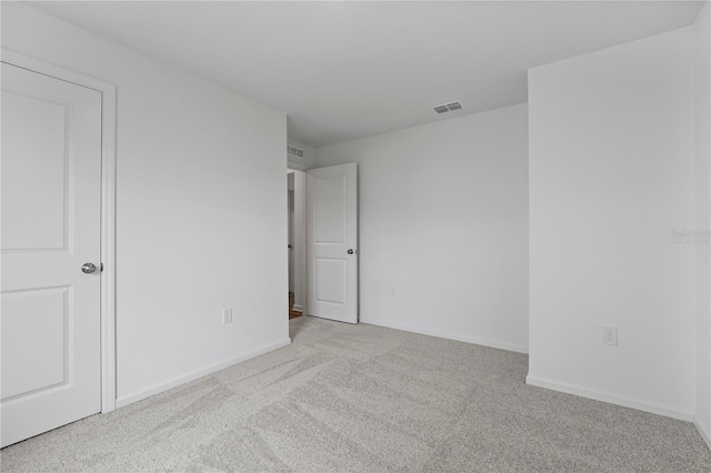 unfurnished room featuring light carpet