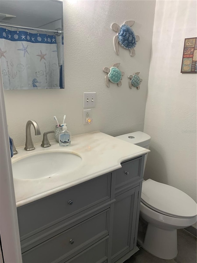 bathroom with vanity with extensive cabinet space and toilet