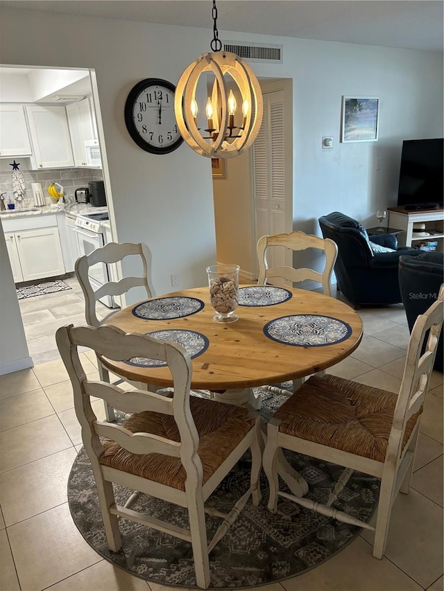 dining area with a notable chandelier and light tile floors