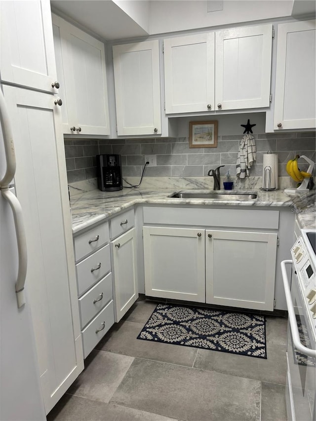 kitchen with backsplash, sink, tile floors, and white cabinets