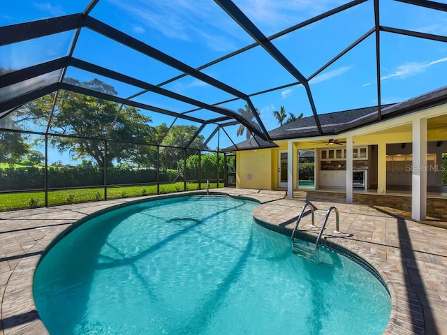 view of swimming pool featuring ceiling fan, a patio, and a lanai